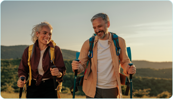 couple-hiking-at-altitude Couple hiking at altitude with trekking poles on a mountain trail.