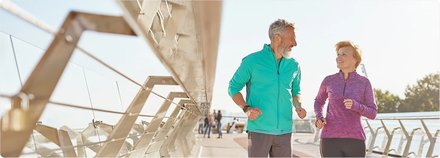 Man and woman jogging outdoors together, representing exercise and an active lifestyle.